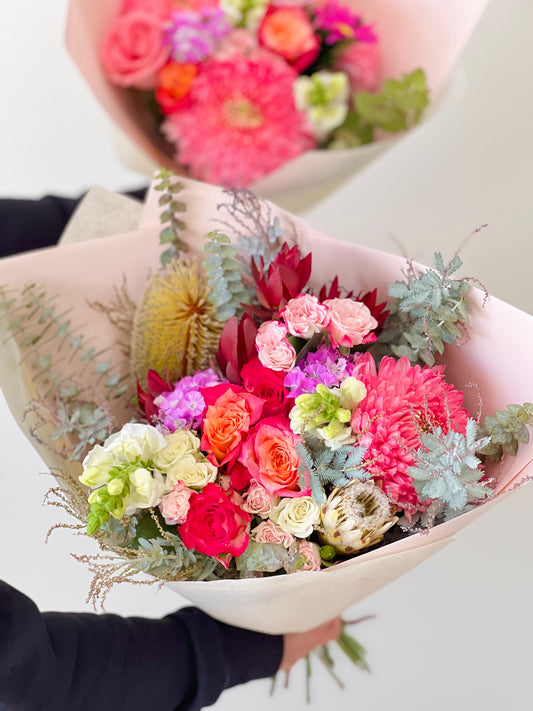 Seasonal, native, roses and foliages in a bouquet.